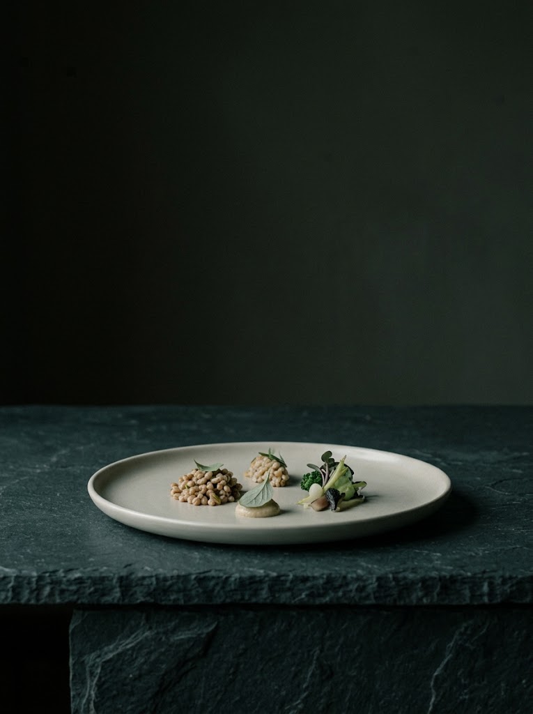 A single plated dish on a dark stone table